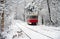 Old red yellow tram rides through the snowy forest. Winter plot.