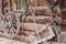 Old remnants of agricultural utensils hang on a wall of logs