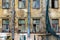 old residential building awaiting reconstruction or demolition. Facade with windows of crumbling plaster, scraps of green protect