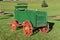 Old restored green grain wagon with a buckseat