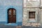 Old and restored nearby. Old wooden door of a shabby demaged house facade. A small town in the mountains of Slovenia