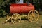 Old restored water tank resting on a wood wheeled trailer