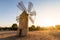 Old restored windmill in the countryside at sunset with the sun behind on the island of Majorca, Spain