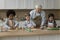 Old retired grandfather teaching diverse grandkids to bake