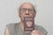 Old retired man not combed in gray  shirt is passport in his hand.