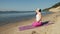Old retired woman doing some yoga on the beach super slow motion