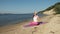 Old retired woman doing some yoga on the beach super slow motion