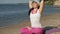 Old retired woman doing some yoga on the beach super slow motion