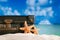 Old retro antique suitcase on beach with starfish, ocean and sky