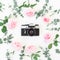 Old retro camera and floral frame of roses with eucalyptus branches on white background. Flat lay, top view