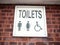 Old retro lettering sign on wall toilets male and female and dis