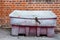 An old and retro looking red salt grit locked container outside