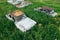 Old retro rusty abandoned cars in high green grass, cemetery of vintage autos, aerial view