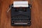 Old retro vintage typewriter with paper on wooden board