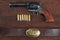 Old revolver with cartridges and U.S. Army soldier& x27;s belt with a buckle