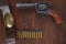 Old revolver with cartridges and U.S. Army soldier& x27;s belt with a buckle