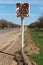 Old road sign on the side of the road. Cracked illegible inscription on a vintage village signpost in a poor quarter. Cracked