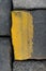 Old road tiles with yellow paint. Street, road details. Vertical background