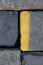 Old road tiles with yellow paint. Street, road details. Vertical background