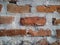 Old roman brick. The restored wall of the building of the Roman conquerors. Warm brown-red shades of uneven bricks. Archaeological