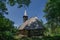 Old Romanian traditional wooden church surrounded by trees in countryside in Transylvania region, Romania