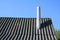 Old roof asbestos roof slates and chimney against blue sky