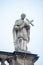 Old roof statute of priest or monk holding a big cross at Dome base of the Cathedral of Holy Trinity, historical center of Dresden