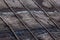 Old rotten black ruberoid shed gable roofing close-up with selective focus and blur