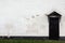 Old Rough Brick Wall and door in black with a visor, background of a brick wall. Stone Wallpaper. An Old Wall With Peeling Plaster