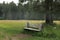 Old rough wooden country bench in the forest next to the path, tourist hiking, secluded places of nature