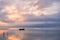 Old rowboat on the lake at sunset and great clouds