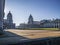 Old Royal Naval College doors entrance near Times river and the sun shining above.