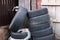 Old rubber tires randomly lie near an abandoned wooden house