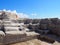 Old ruined abandoned quarry workings with geometric rectangular carved stone surface in sunlight and shadow