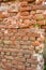 Old ruined brick wall with some concrete and cracks. Damaged antique brick wall