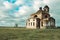 Old ruined broken Church on the background of the sky and a dry field, blurred clouds