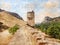 An old ruined fortress wall against a background of mountains an