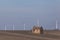 Old ruined house on agricultural ground with wind warm in background