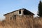 Old ruined house in the village in a dirty fence uninhabited abandoned building