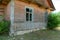 An old ruined wooden house in the village. Details of the facade of a historic wooden house with carved shutters and vintage decor