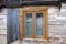 An old ruined wooden house in the village. Details of the facade of a historic wooden house with carved shutters and vintage decor