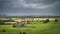 Old ruins of Hore Abbey surrounded by fields and forest, dark dramatic storm sky