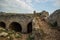 Old ruins of south castle with destroyed stones walls and yard empty space with rocks and cactus