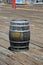 An old Rum Barrel sits on a wooden board walk. old dirty wooden keg or rum barrel
