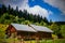 Old rural wooden house with newly built building on hillside with woods