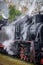 Old Russian locomotive on the railway. Old black locomotive. Smoke from the engine. Russian railway. Russia, Leningrad region