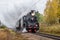 Old Russian locomotive on the railway. Old black locomotive. Smoke from the engine. Russian railway. Russia, Leningrad region