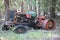 OLD RUSTED ABANDONED TRACTOR NEXT TO A CLUMP OF TREES