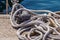 Old rusted mooring bollard with knotted nautical ropes