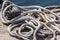 Old rusted mooring bollard with knotted nautical ropes